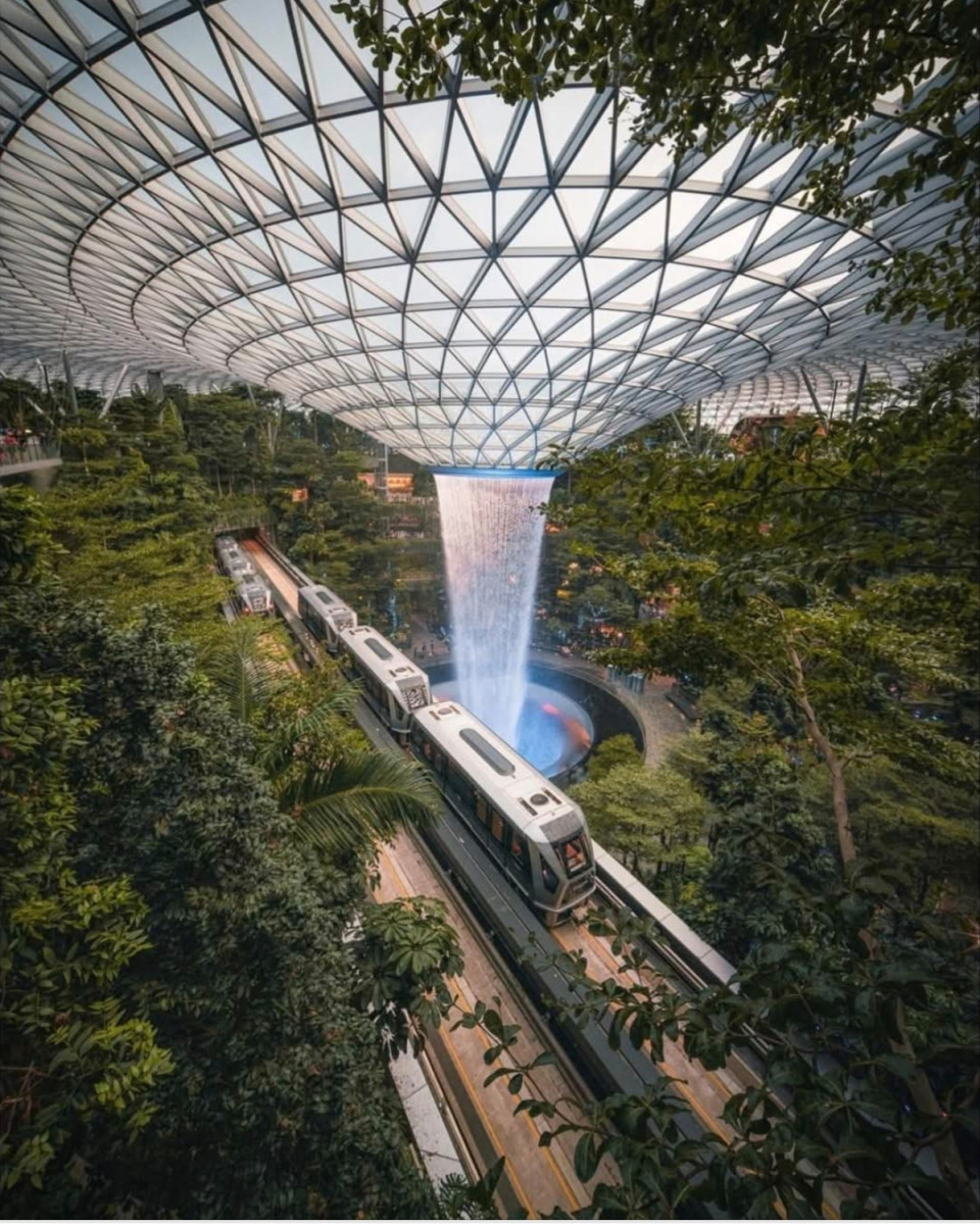 Jewel Changi repülőtér, utazási csomópont, SzingapúrBevásárló- és szórakoztató központ is, egy nagy üvegkupolát és alatta egy teraszos erdőt hoztak létre a világ legnagyobb és kivilágítható beltéri vízesésével. A Rain Vortex 40 méter magasból zúdul alá és esőerdő, kirándulóösvények veszik körül.
