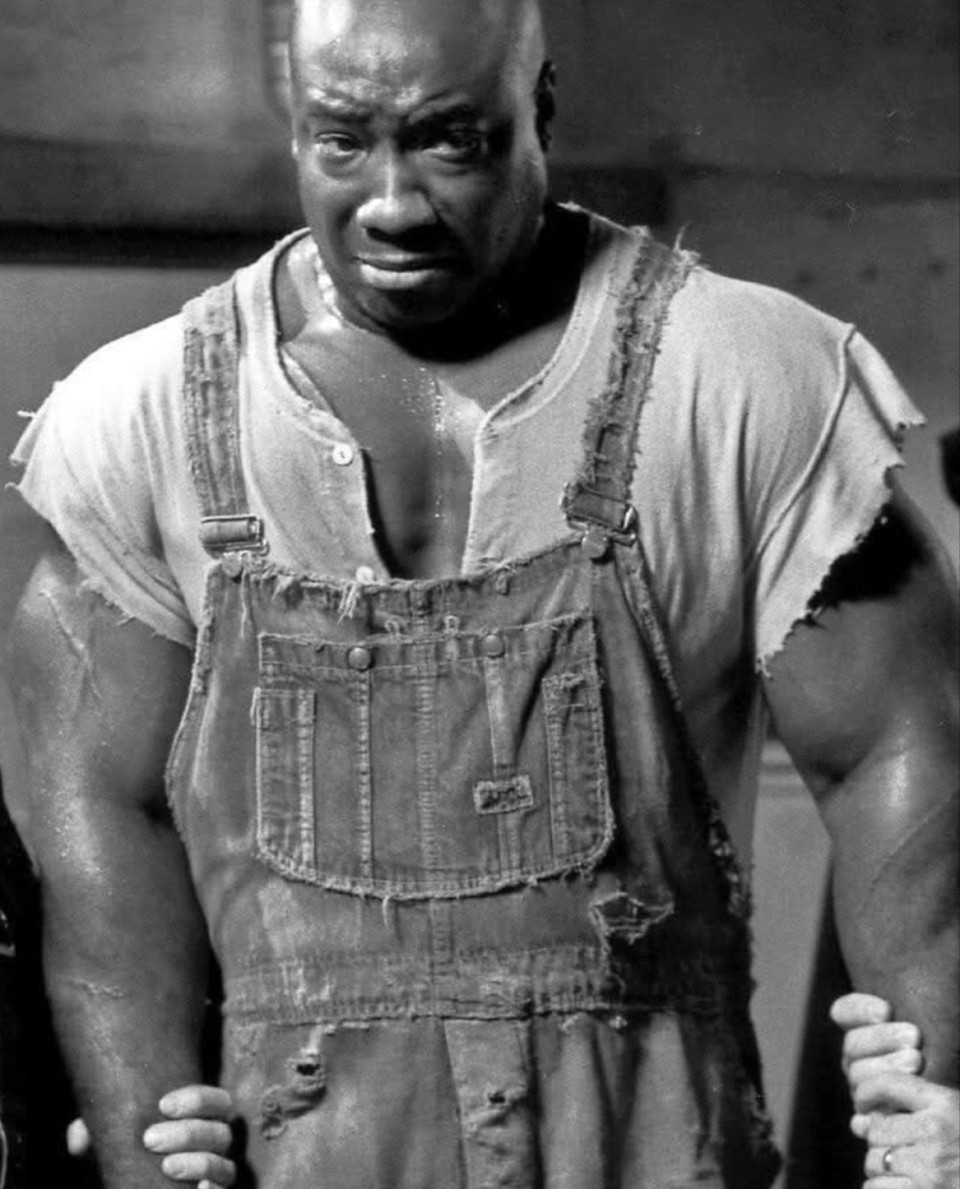 Mielőtt Oscar-díjra jelölték volna, mielőtt könnyes szemével és gyengéd kéznyújtásával megérintette volna a világ szívét, Michael Clarke Duncan árkot ásott a chicagói gázműveknél.Impozáns jelenség volt, erőt sugárzó... de meglepően félénk.Édesanyja, aki egyedül nevelte fel, mindig ezt mondta neki:„A termeted ajándék, de az igazi erőd a gyengédséged.”Évekig dolgozott kidobóként éjszakai klubokban, hírességeket védelmezve.Mások testét óvta, miközben arról álmodott, hogy lelkeket érint meg – a filmvásznon.De senki sem hitt benne.„Túl nagy” – mondták.Azt is mondták, „túl jó”.A történet szerint egy nap, az Armageddon forgatásán Bruce Willis meglátta őt sírni.Nem volt alakítás.Az fájdalom volt. Az igazság.És abban a pillanatban – legalábbis a legenda szerint – Bruce ráébredt, hogy megtalálta John Coffey-t: a szelíd óriást, aki kívülről félelmetesnek tűnt, de belül csak segíteni akart.Azt beszélik, Michael a Halálsoron minden jelenetében sírt.Nem játszotta – emlékezett.Talán édesanyja szavai jutottak eszébe.Talán az idegenek tekintete.Talán a félreértettség súlya.„Az erő nem azt jelenti, hogy ütni tudsz.Néha azt, hogy állva maradsz… anélkül, hogy összeroppannál.”Amikor 2012-ben elhunyt, a világ nem az izmait siratta meg.A lelkéért hullottak a könnyek.Mert néha a legnagyobbak a legérzékenyebbek.És néha egy óriásnak nem kell ordítania.Csak valakire van szüksége, aki hisz benne.